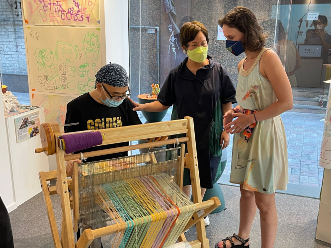 艺术家麦惠鸿向法国女孩展示使用SAORI织布机