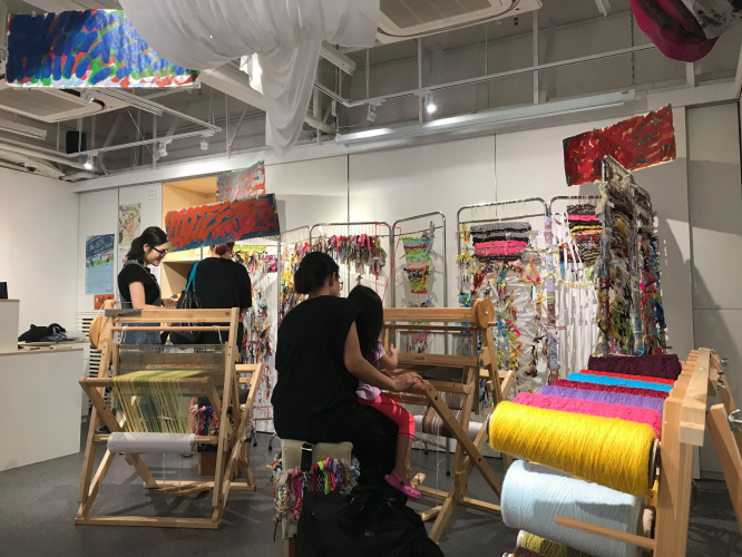 Visitors experiencing SAORI weaving